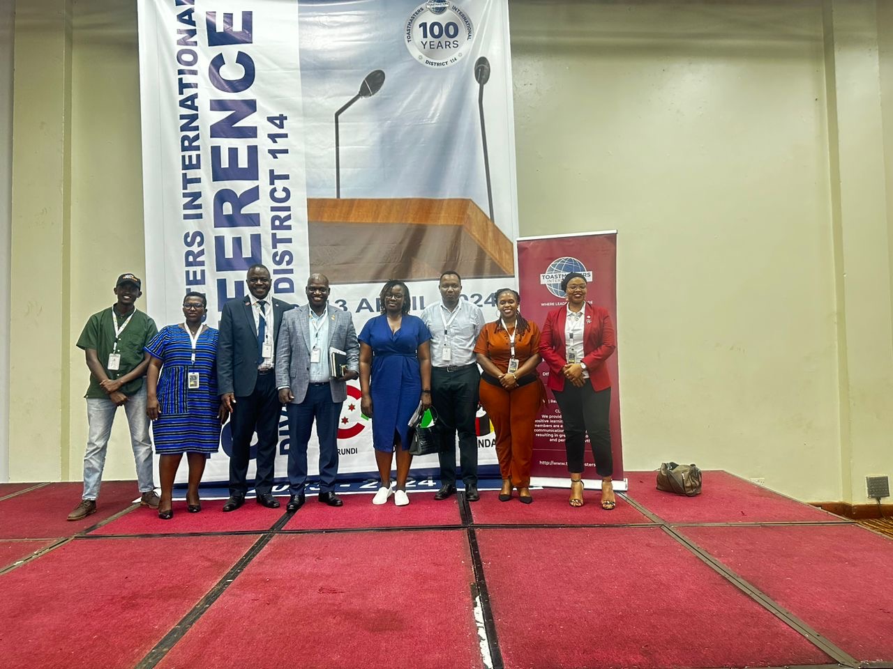 DJ facing a crowd at his deck. Photo with a purple hue